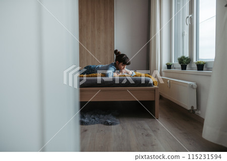 Young schoolgirl struggling with learning at home, doing homework. Learning difficulties in children 115231594