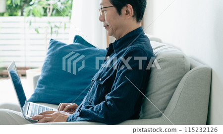 在沙發上使用電腦的男人 115232126