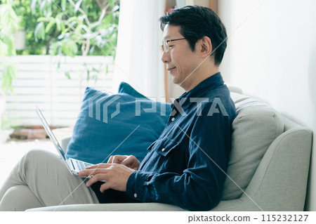 在沙發上使用電腦的男人 115232127