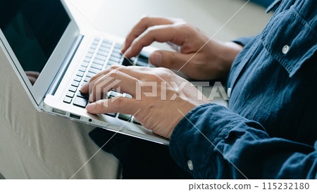 在沙發上使用電腦的男人 115232180