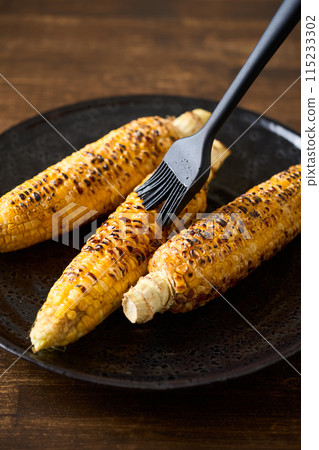 將醬汁塗在烤好的玉米上 115233302