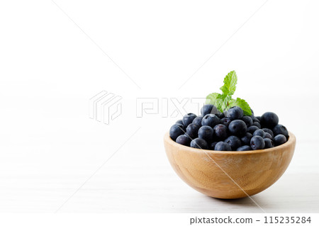 Ripe organic blueberries on white wooden table background. Selective focus. Ripe organic blueberries on white wooden table background. Selective focus. 115235284