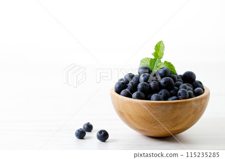 Ripe organic blueberries on white wooden table background. Selective focus. 115235285