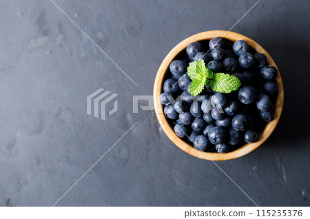 Ripe organic blueberries on black stone table background. Selective focus. 115235376