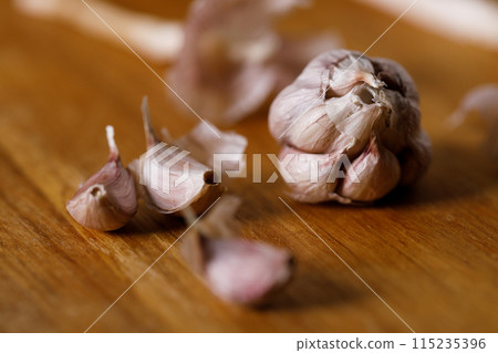 Ripe organic garlic clove and bulb on wooden background.  Close-up. Selective focus. 115235396
