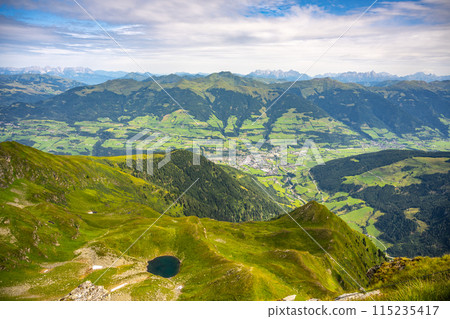 Overlooking the scenic Mittersill in Salzach Valley, Austrian alpine landscape with verdant hills and a small lake under a clear sky. Hohe Tauern National Park, Austria Overlooking the scenic Mittersill in Salzach Valley, Austrian alpine landscape with verdant hills and a small lake under a clear sky. Hohe Tauern National Park, Austria 115235417