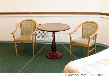 Small cramped hotel room with old furniture 115236406