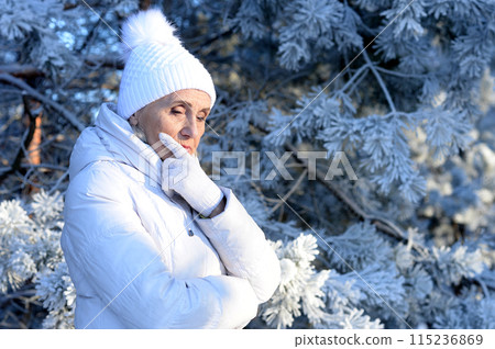 Beautiful elderly woman posing in a snowy winter park Beautiful elderly woman posing in a snowy winter park 115236869