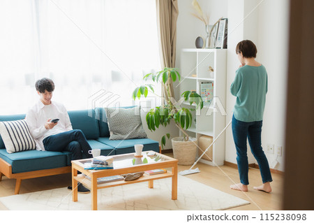 一名清潔工的女性和一名使用智慧型手機的男性 一名清潔工的女性和一名使用智慧型手機的男性 115238098