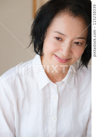 A middle-aged woman writing a letter to her family in the living room 115238339