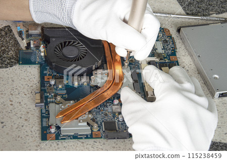 image of a mechanic repairing computer motherboard, electronic motherboard repair 115238459