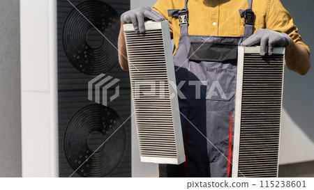 Man holding two clogged air filters from a home ventilation system. Man holding two clogged air filters from a home ventilation system. 115238601