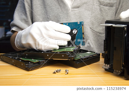 2.5-inch hard drives are still popular today, technician holding a hard drive in hand 115238974