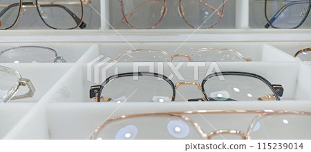 Several pictures of eyeglasses are placed on the shelf. 115239014