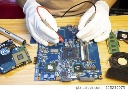 Technician repairing computer motherboard, notebook motherboard Technician repairing computer motherboard, notebook motherboard 115239075