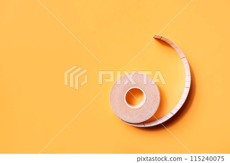 Adhesive tapes for the face in rolls on a yellow background Adhesive tapes for the face in rolls on a yellow background 115240075
