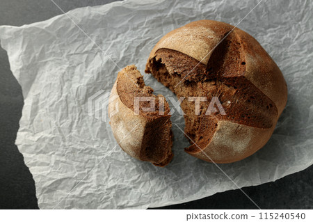 beautiful homemade raisin bread on parchment. Torn piece 115240540