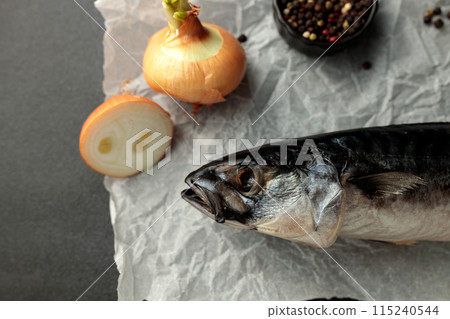 Dried mackerel herring on a black cutting board on a black background Dried mackerel herring on a black cutting board on a black background 115240544