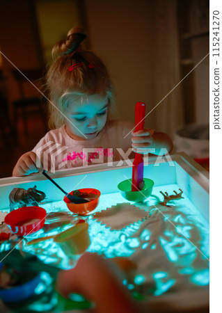 Adorable girl playing on sensory box. 115241270