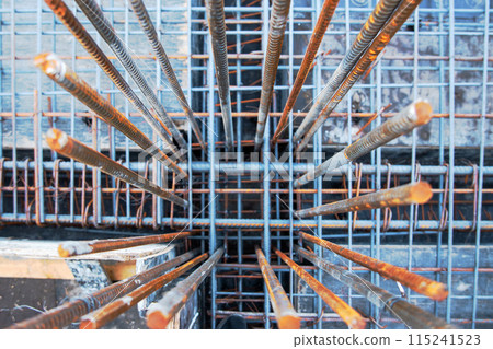 Embedded frame for a column made of steel reinforcement protrudes from the main reinforcement frame of the floor on a construction site. Embedded frame for a column made of steel reinforcement protrudes from the main reinforcement frame of the floor on a construction site. 115241523
