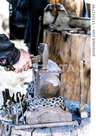 Blacksmith in a forge at work on an anvil. Hot metal forging 115241748