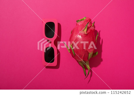 One whole dragon fruit and sunglasses on pink background, top view 115242652