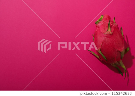 One whole dragon fruit on pink background, space for text 115242653