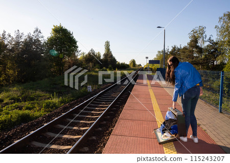 Teenagers spilled the contents of a travel suitcase on the train platform. An unfastened travel suitcase. Adventure on the platform. Teenagers spilled the contents of a travel suitcase on the train platform. An unfastened travel suitcase. Adventure on the platform. 115243207