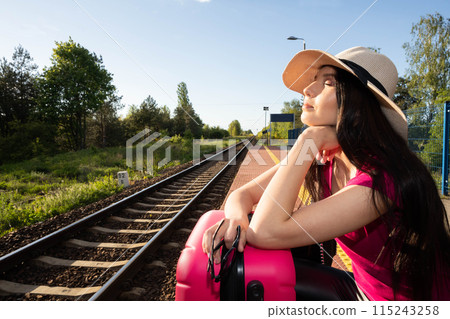 An adult teenager waiting on a train platform for a late train for a dream train journey to distant countries. 115243258