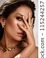 Beautiful tanned woman with smoky makeup, gold jewelry and ice. Beauty face. 115244257