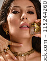 Beautiful tanned woman with smoky makeup, gold jewelry and ice. Beauty face. 115244260