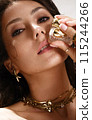 Beautiful tanned woman with smoky makeup, gold jewelry and ice. Beauty face. 115244266
