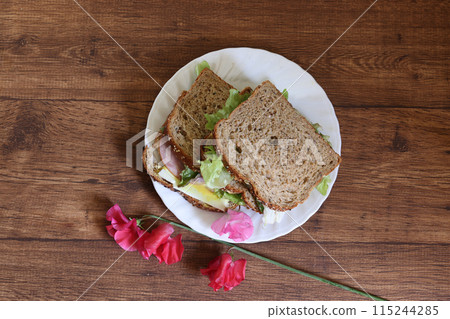 Organic bread sandwich on a plate on a wooden background Organic bread sandwich on a plate on a wooden background 115244285