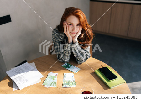 High-angle view portrait of upset woman counting dollar bills and feeling worried about financial problem. Stressed housewife female looking frustrated thinking of money debt or bankruptcy 115245385