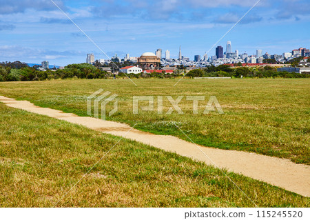Dirt trail through grassy field and skyline with Palace of Fine Arts rotunda and city skyscrapers Dirt trail through grassy field and skyline with Palace of Fine Arts rotunda and city skyscrapers 115245520