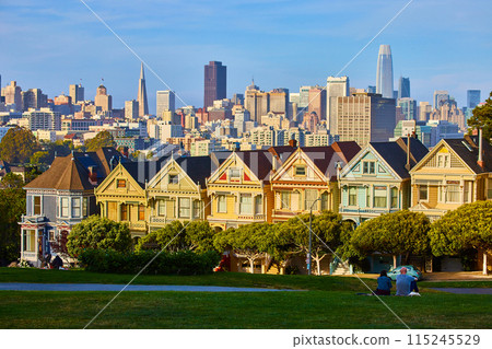 Couple enjoying sunset lighting on The Painted Ladies and downtown San Francisco 115245529