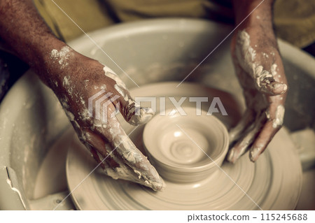 Close up picture of hands working with wet clay and molding its shape Close up picture of hands working with wet clay and molding its shape 115245688
