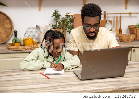African American father helps his daughter with lessons during distance education 115245738