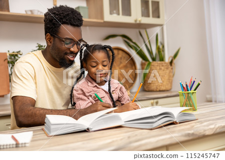 Happy father helping schoolgirl daughter studying 115245747