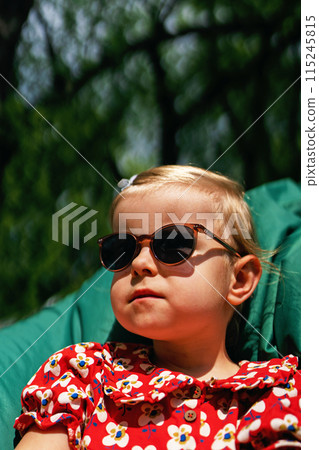 Portrait of a fashionable, stylish beautiful little girl in sunglasses and a red dress. Portrait of a fashionable, stylish beautiful little girl in sunglasses and a red dress. 115245815