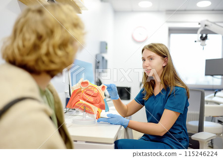 The otolaryngologist explains to the patient about his illness at the appointment. A professional ENT doctor demonstrates a model of the human nose. Treatment of inflammation disease of nose. 115246224