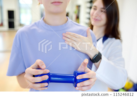 The rehab doctor conducts the patient's appointment in the gym. The PMR specialist trains the patient to perform recovery exercises correctly. 115246812