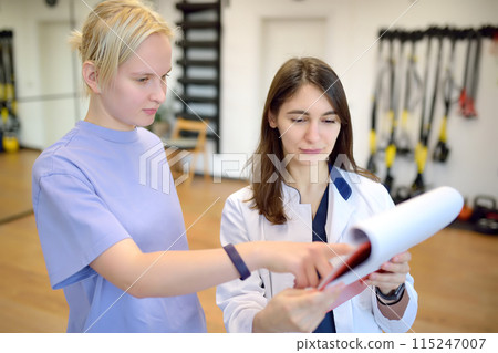 The rehab doctor conducts the patient's appointment in the gym. Before starting an individual session, the rehabilitologist make a patient survey and fills out a questionnaire. 115247007