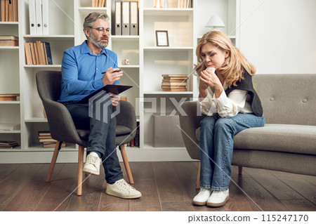 Man psychologist discusses solutions and support with her troubled female patient in his office 115247170