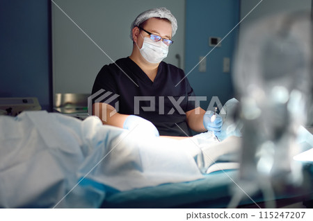 Professional vascular surgeon is in the operating room of the clinic during vein surgery. Phlebectomy. Modern technology of deep vein thrombosis treatment. 115247207