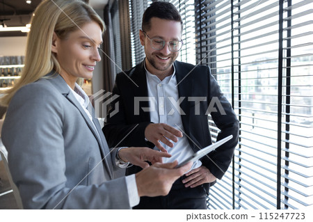 Woman and man discussing business ideas with digital laptop in office 115247723