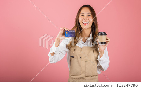 Portrait Asian happy young woman barista bar tender coffee maker holding coffee tea hot cup and credit card studio shot isolated on pink background, female smiling hold takeaways cup for payment Portrait Asian happy young woman barista bar tender coffee maker holding coffee tea hot cup and credit card studio shot isolated on pink background, female smiling hold takeaways cup for payment 115247790