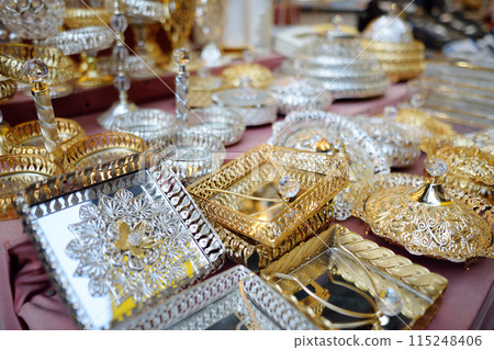 Decorative silver and gold trays and plates with mirrored bottoms, openwork patterns and crystal are sold at the Grand Bazaar in Istanbul. 115248406