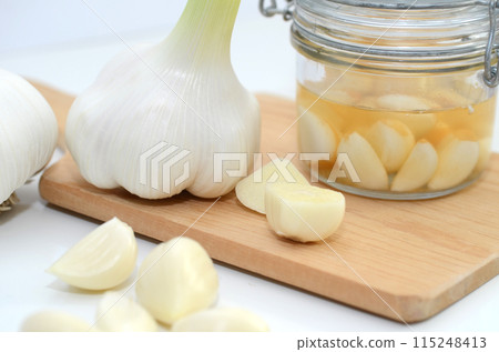 Peeled garlic and garlic in vinegar 115248413