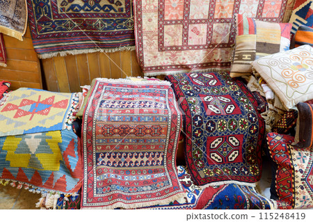 Variety of multi colored turkish carpets and prayer mats offered for sale on the market Grand Bazaar, Istanbul. Authentic gifts from travels by Turkey. Variety of multi colored turkish carpets and prayer mats offered for sale on the market Grand Bazaar, Istanbul. Authentic gifts from travels by Turkey. 115248419
